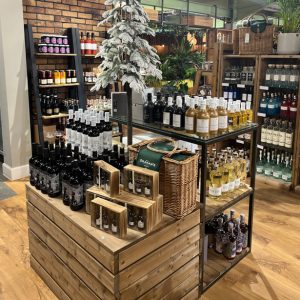 Hotel retail experience, food shop display, drink and wine display, gift shop, sea-side, visitor centre, rustic shelving, Central Display with Metal Table and plinths